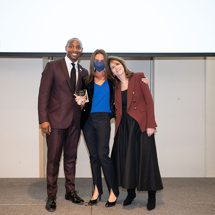 Four women posing with their two NYU Alumni awards